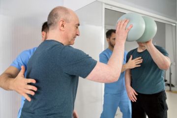 pacient efectueaza exercitii cu mingea in terapia de reeducare neuromotorie